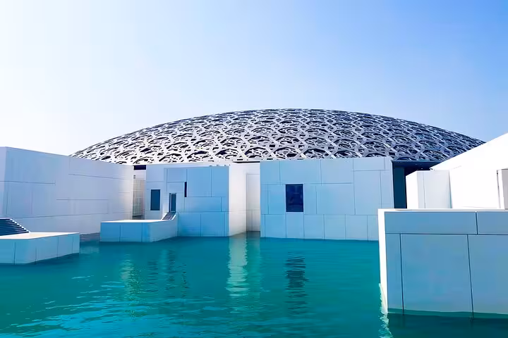 Louvre Abu Dhabi dome over turquoise water, iconic highlight on a private full-day Abu Dhabi city tour