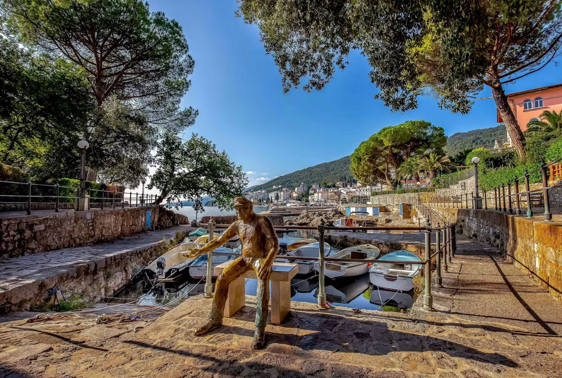 Small marina near Lovran with bronze fisherman statue and boats, highlight of Kvarner Bay coastal tour