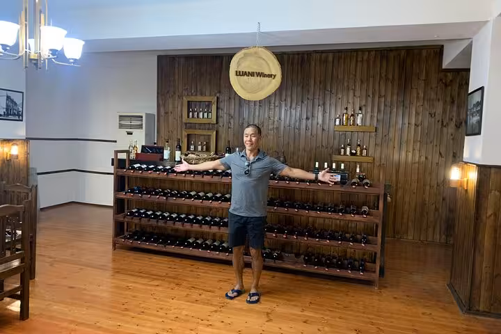 Welcoming guest in the cozy interior of Luani Winery in Berat, surrounded by shelves filled with exquisite wine.