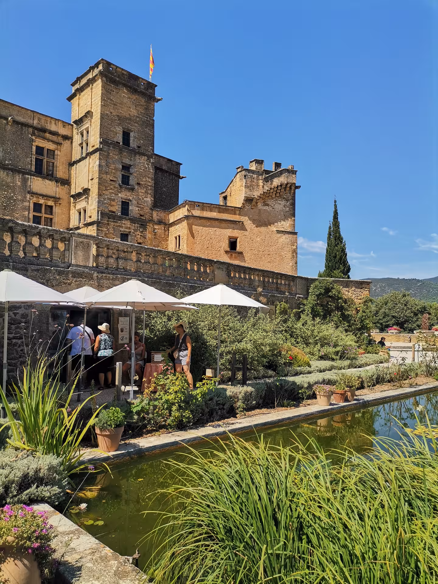 Historic Luberon château and garden pond in Provence, scenic stop on a Provençal picnic tour from Avignon