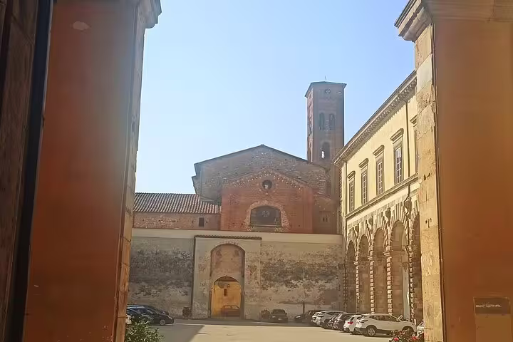 Historic church and courtyard framed by medieval walls in Lucca, Italy, seen on a private Pisa and Lucca excursion with lunch