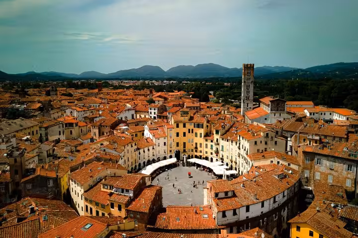 Enjoy a panoramic view of Lucca's historic Piazza dell'Anfiteatro, a highlight on the Lucca and Pisa day tour.