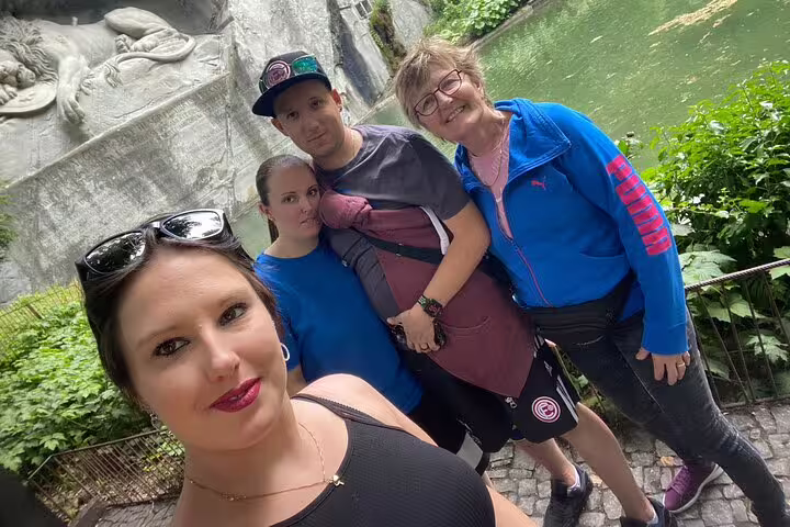 Travelers selfie near Lucerne Lion Monument and pond on a self-guided scavenger hunt sightseeing tour