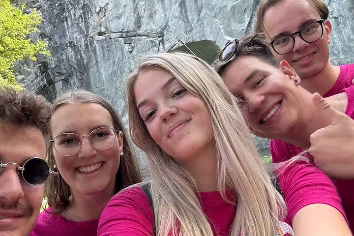 Smiling group selfie at Lucerne Lion Monument on a self-guided scavenger hunt and sights walking tour