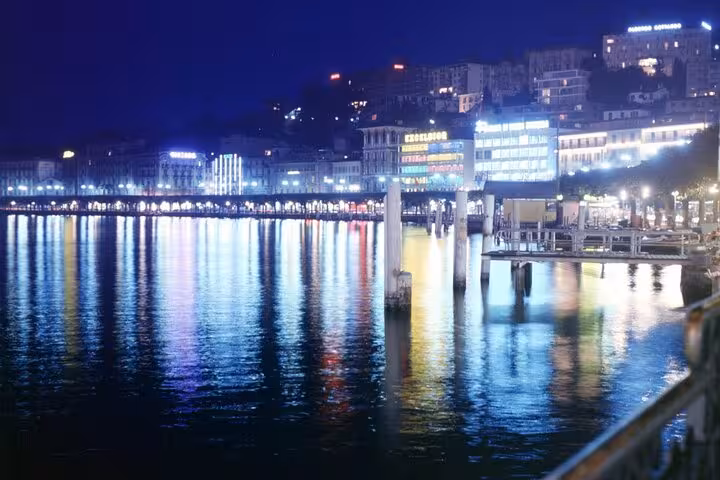 Lugano lakeside promenade at night with bright city lights reflecting on Lake Lugano during city tour