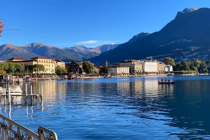 Lugano city tour panorama of Lake Lugano waterfront, historic buildings and Alps under clear blue sky