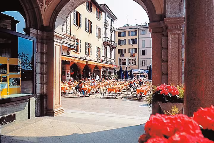 Piazza della Riforma in Lugano with outdoor cafes under historic arcade, highlight of a guided city tour