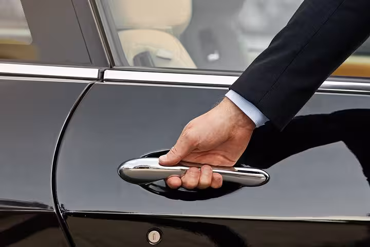 Professional driver opening car door for Luxor to Aswan private transfer, premium sedan pickup service in Egypt