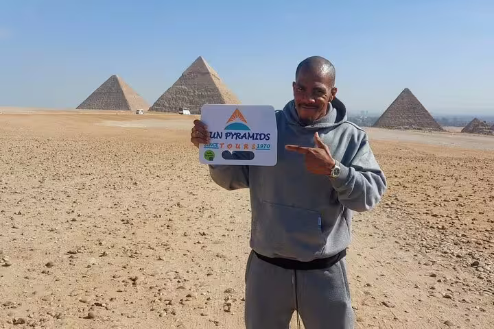 Tour guide with Giza Pyramids backdrop in Cairo, featured on Luxor to Cairo by flight day tour