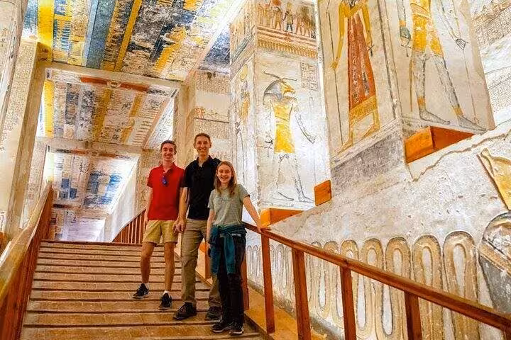 Travelers exploring painted tomb corridor in Luxor on private deluxe Dahabiya with hot air balloon and Abu Simbel