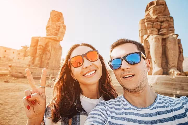 Couple selfie by Luxor Colossi of Memnon on a private Luxor day tour with flexible itinerary and carriage ride