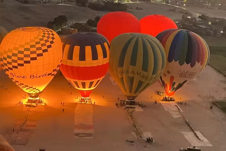 Dawn view of Luxor hot air balloons inflating on the West Bank, sunrise ride with hotel pickup and drop-off