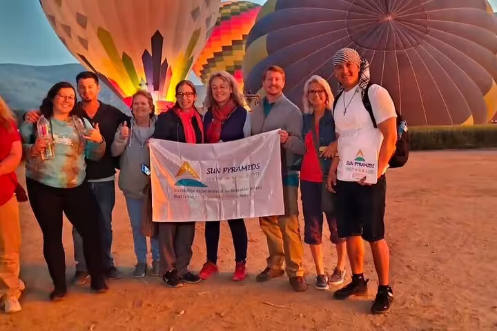 Group photo at Luxor hot air balloon launch site at sunrise, ready for a scenic ride over ancient temples