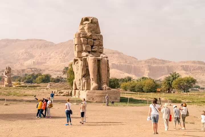 Travelers at the Colossi of Memnon on a Luxor small group day trip from Cairo by plane with guided tour