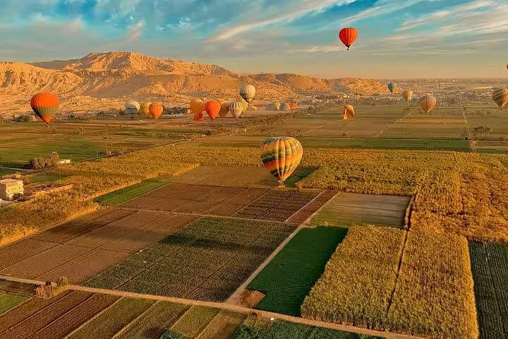 Aerial view of Luxor farmland and desert hills at sunrise with hot air balloons, hotel pickup and drop-off