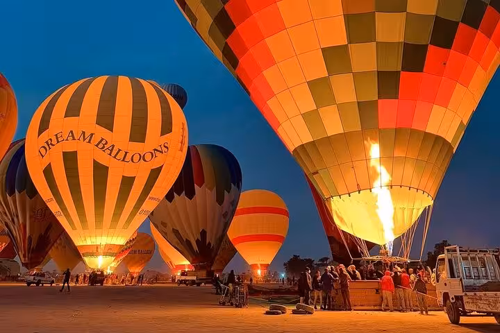 Luxor sunrise hot air balloon ride launch with burners lit, guests boarding, hotel pickup and drop-off