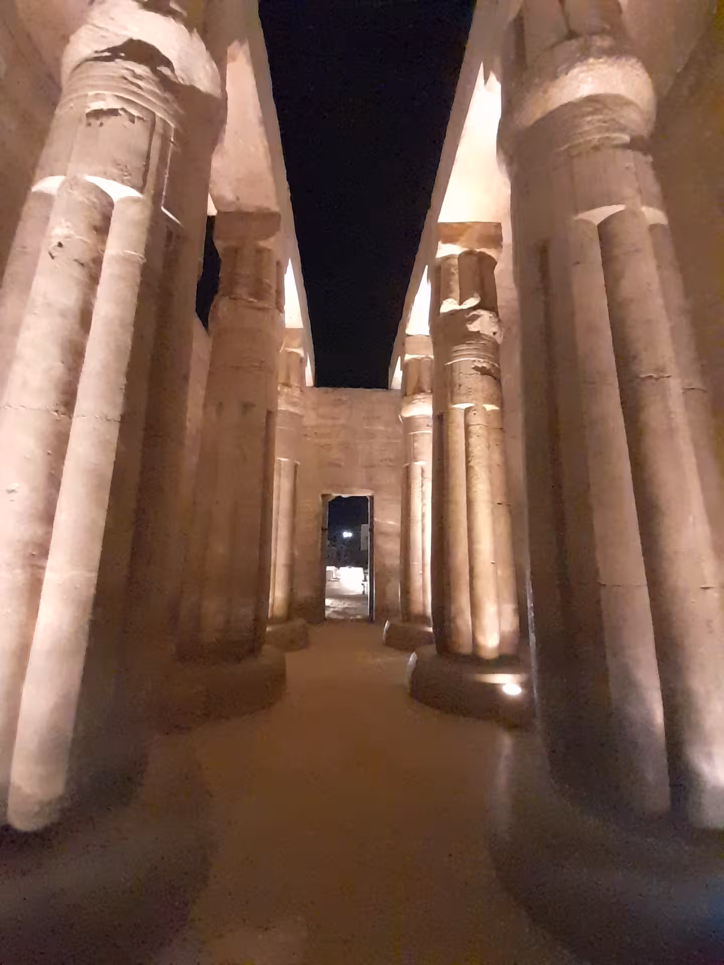 Inside view of Luxor Temple's grand columns lit at night, showcasing the architectural marvels of ancient Egypt.