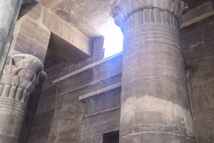 Inside ancient temple hall with massive columns and sunbeam, Luxor Temple from Hurghada and Habu City tour