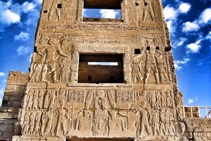 Close-up of ancient hieroglyphs carved on Luxor temple wall, visited on Cairo to Luxor day trip by flight