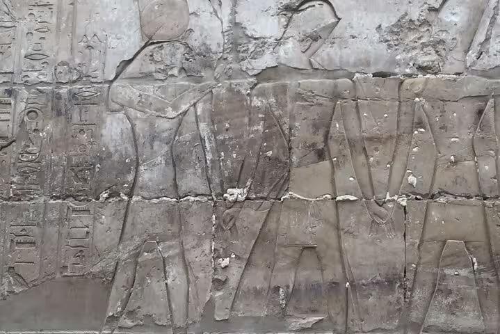 Ancient Egyptian wall relief and hieroglyphs in Luxor temple, seen on private day trip from Hurghada