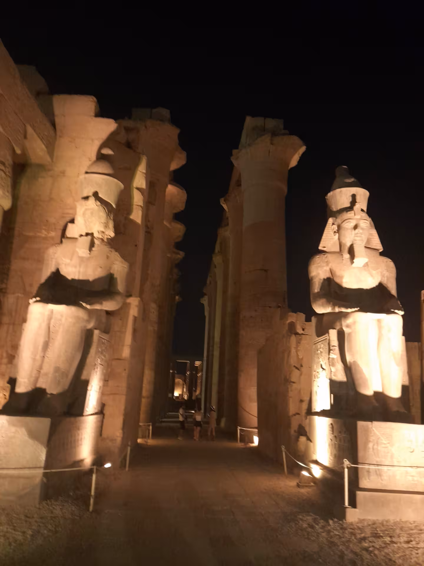 Illuminated statues and columns at Luxor Temple at night, a must-see on Luxor and Aswan multi-day Egypt tours.