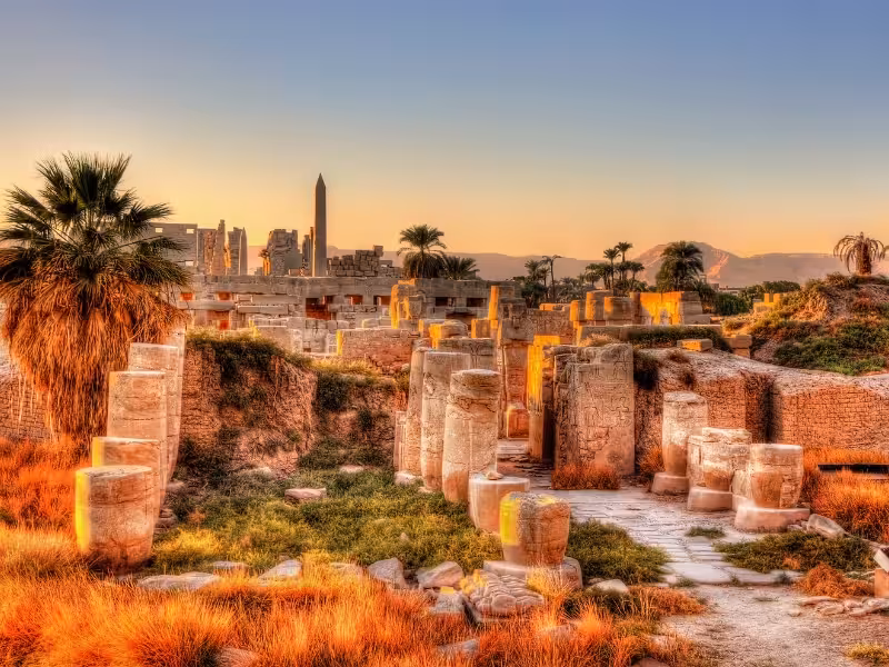 Sunset view of Luxor Temple ruins and palm trees with the obelisk, classic stop on Egypt Highlights