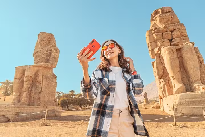 Traveler taking selfie by Colossi of Memnon on Luxor tour from Marsa Alam, West Bank highlights