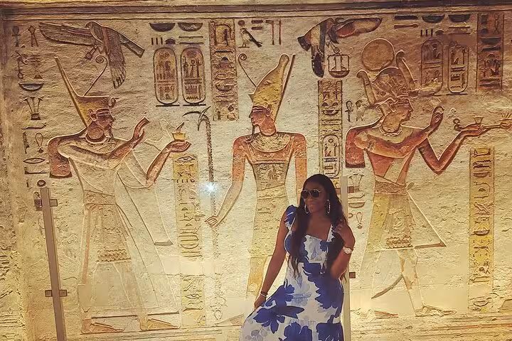 Traveler posing by colorful ancient wall reliefs in Luxor, Valley of the Kings small group day trip