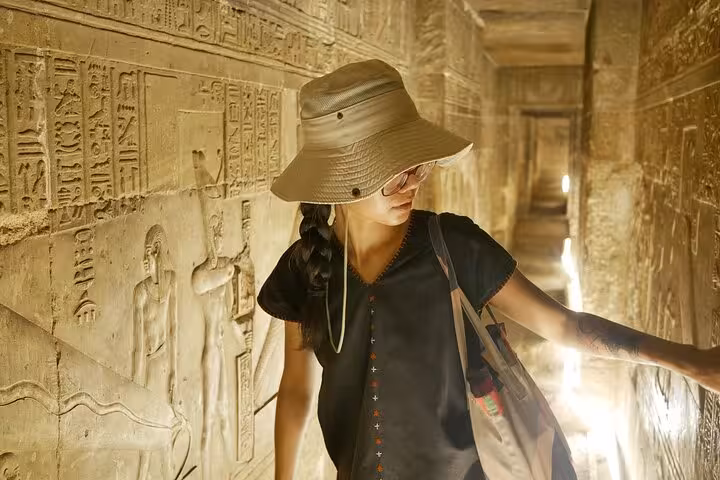 Traveler exploring a Valley of the Kings tomb corridor in Luxor on a day trip from Marsa Alam