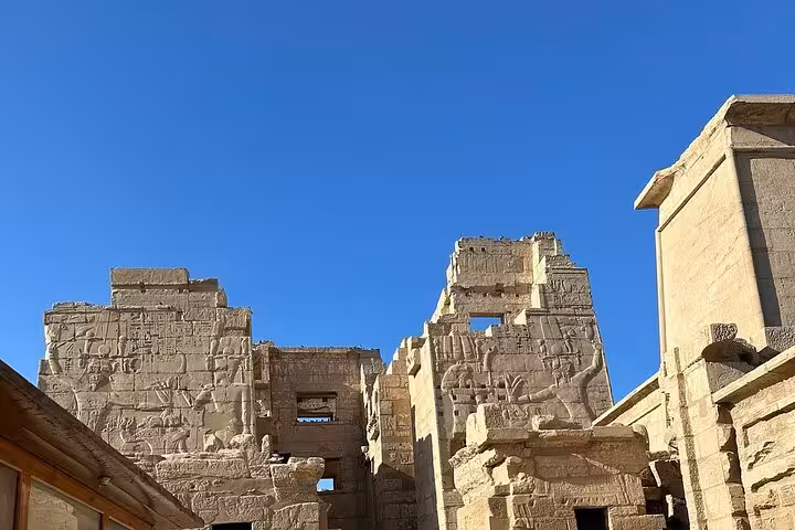 Explore ancient ruins with intricate carvings under a clear blue sky on a Luxor West Bank private day tour.