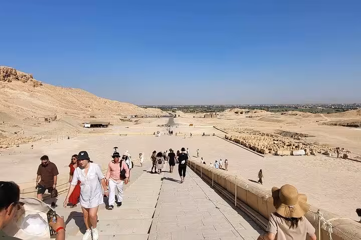 Tourists walking up the grand steps of Luxor West Bank, offering panoramic views of the historic landscape on a private tour.