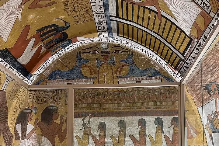 Vibrant ancient Egyptian murals and hieroglyphs cover the arched ceilings of a tomb in Luxor West Bank.
