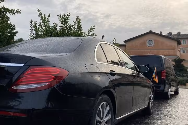 Luxury black car ready for private transfer from Fiumicino Airport to Rome, offering comfort and style.