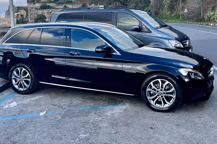 Luxury black sedan ready for private transfer from Rome to Amalfi Coast, ensuring comfort and style.