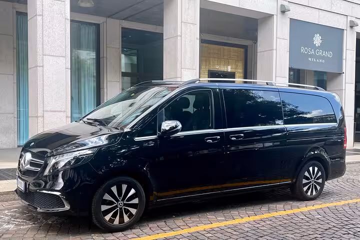 Luxury black van parked outside Rosa Grand hotel in Milan, ideal for Milan MXP airport transfers to city center.