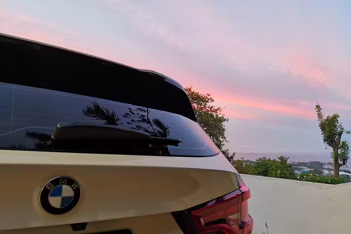 Luxury BMW with scenic Seychelles sunset, perfect for VIP transport services and elegant travel experiences.