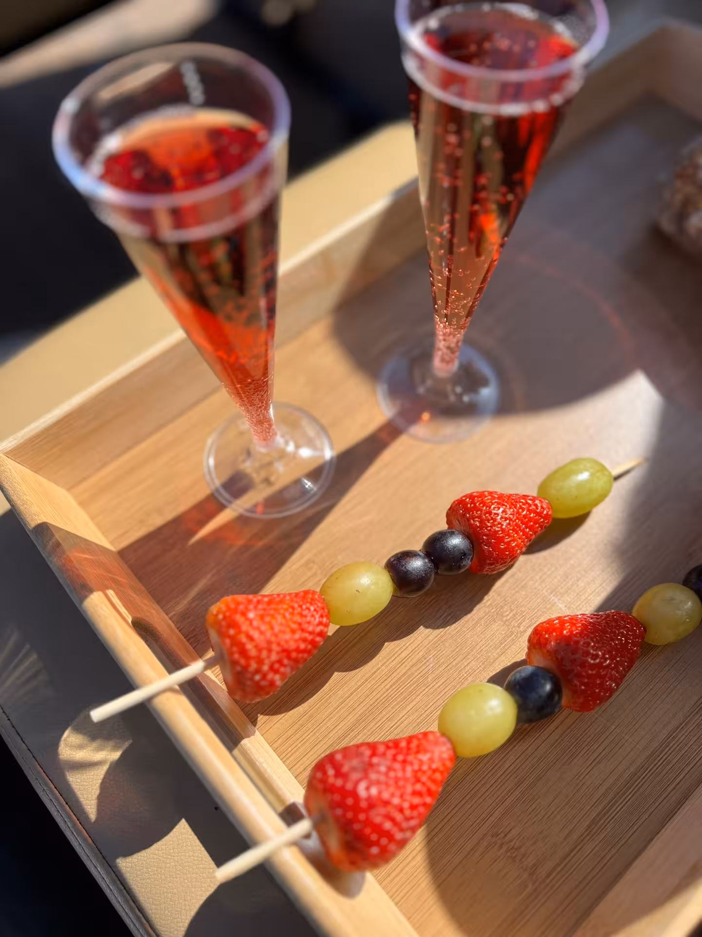 Gourmet fruit skewers and sparkling rosé served on deck during a luxury tailor-made boat charter experience