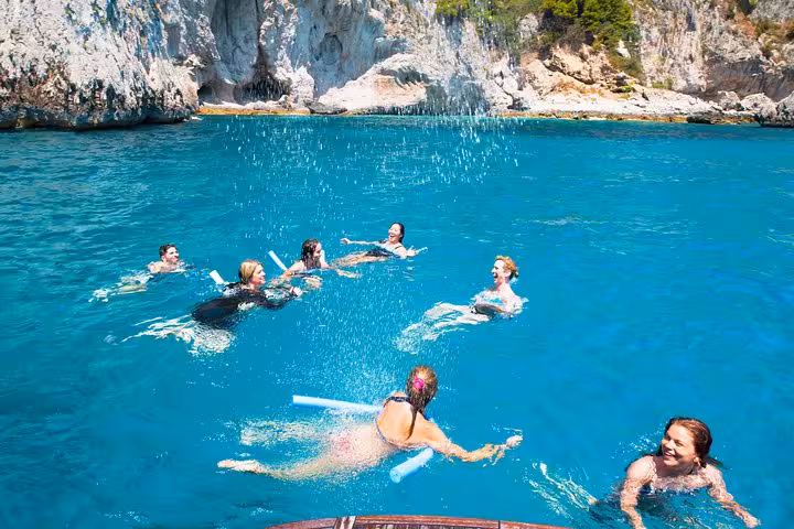 Group enjoying a refreshing swim in the crystal-clear waters during a luxury boat tour along the Amalfi Coast.