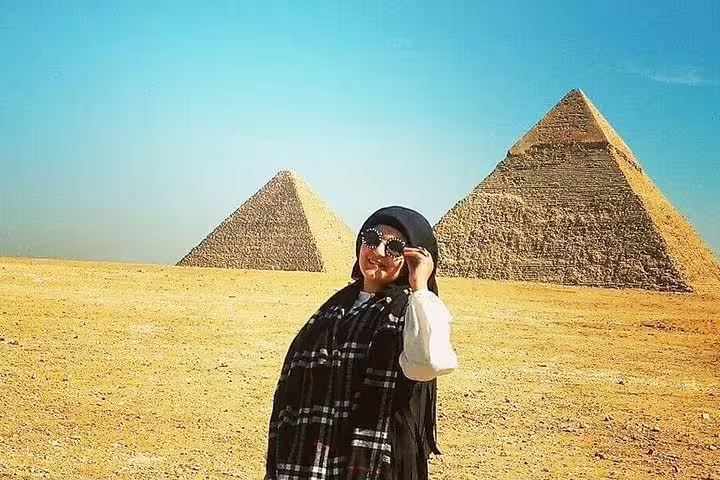 Traveler posing by the Pyramids of Giza in Cairo, included in Luxury 8-day Cairo package with Oberoi Philae cruise