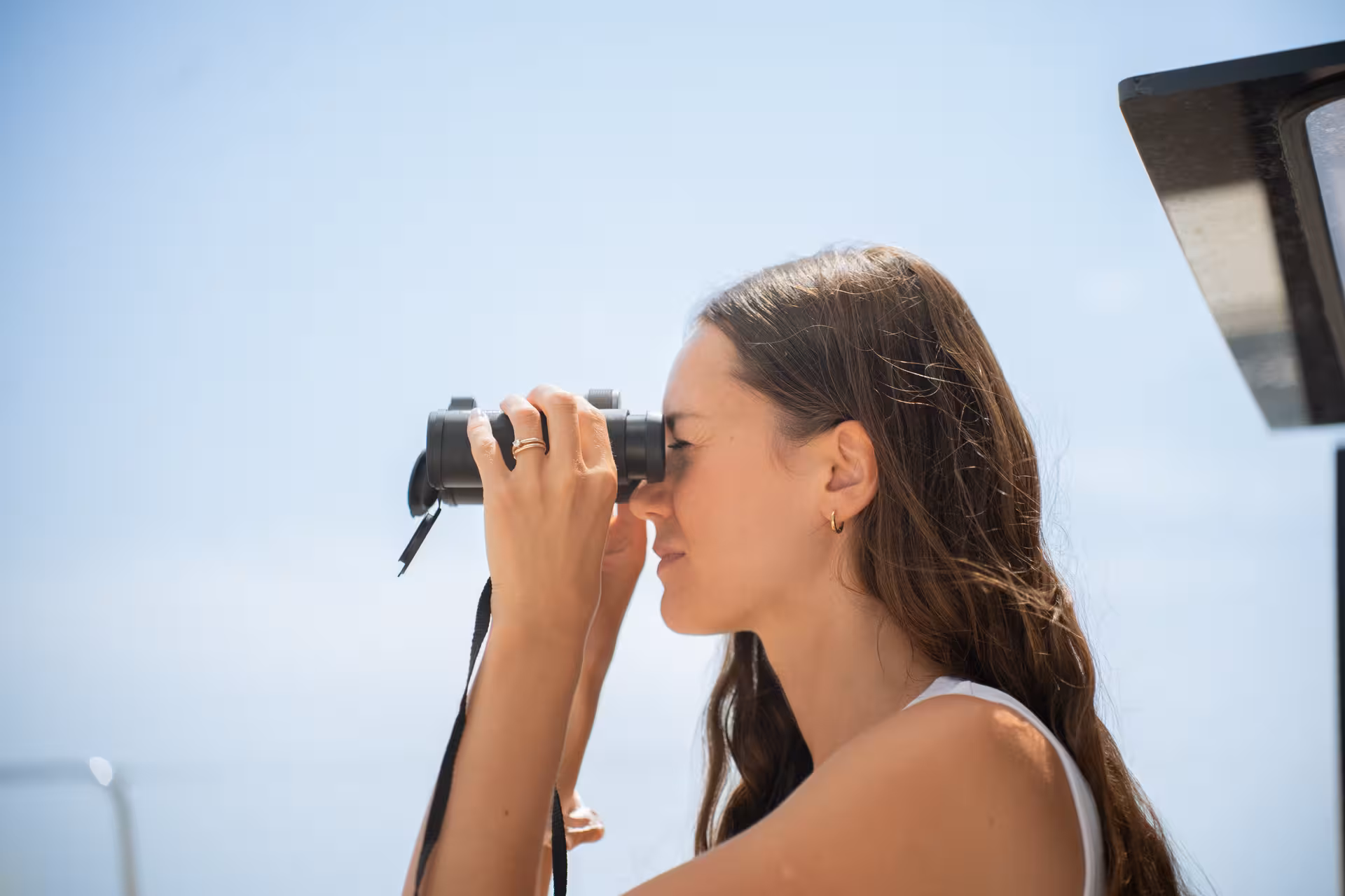 Guest using binoculars on Bali 4.2 luxury catamaran during 3-hour private Barcelona sailing cruise