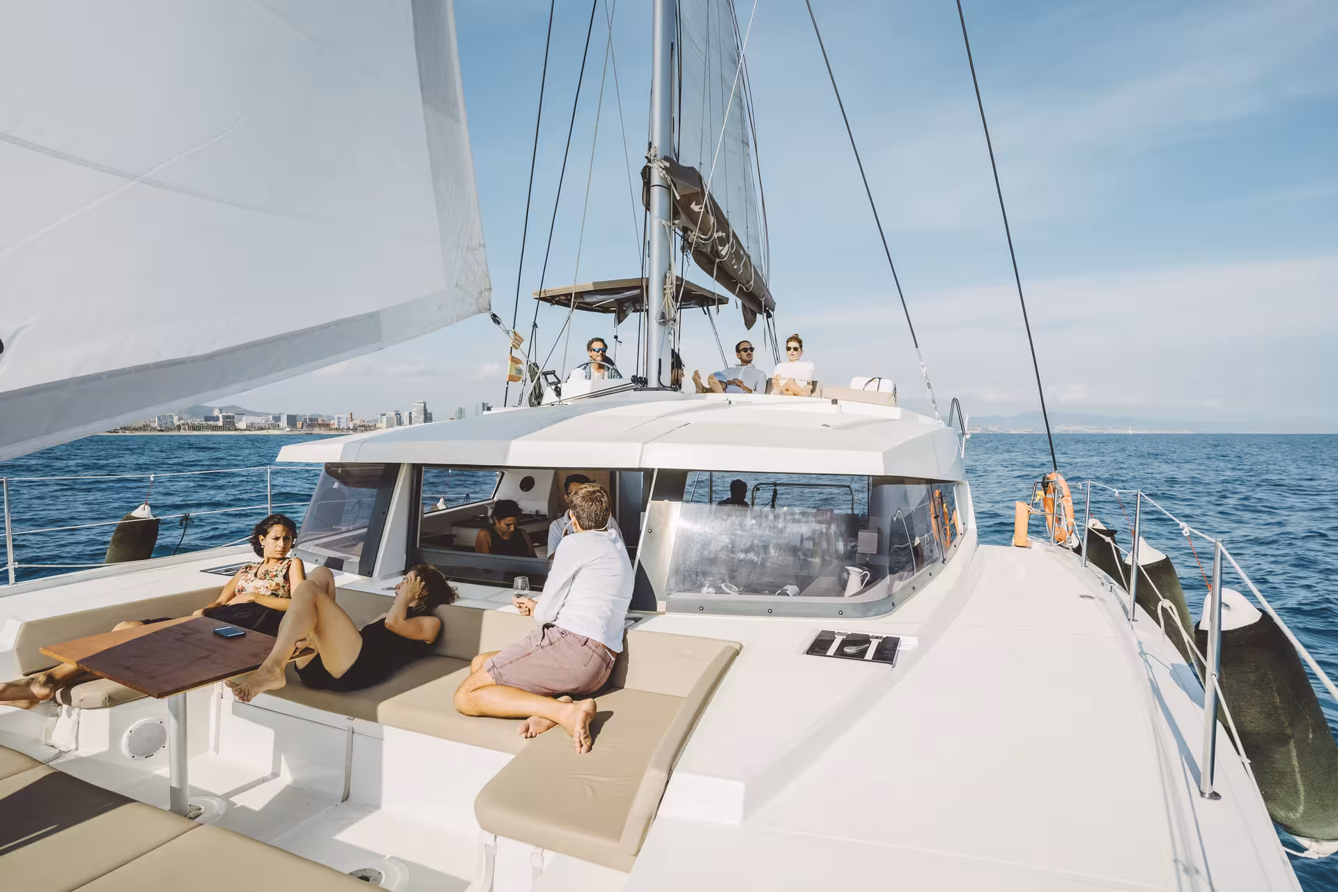 Guests relaxing on deck of Bali 4.1 private luxury catamaran in Barcelona, 2-hour Mediterranean sailing experience
