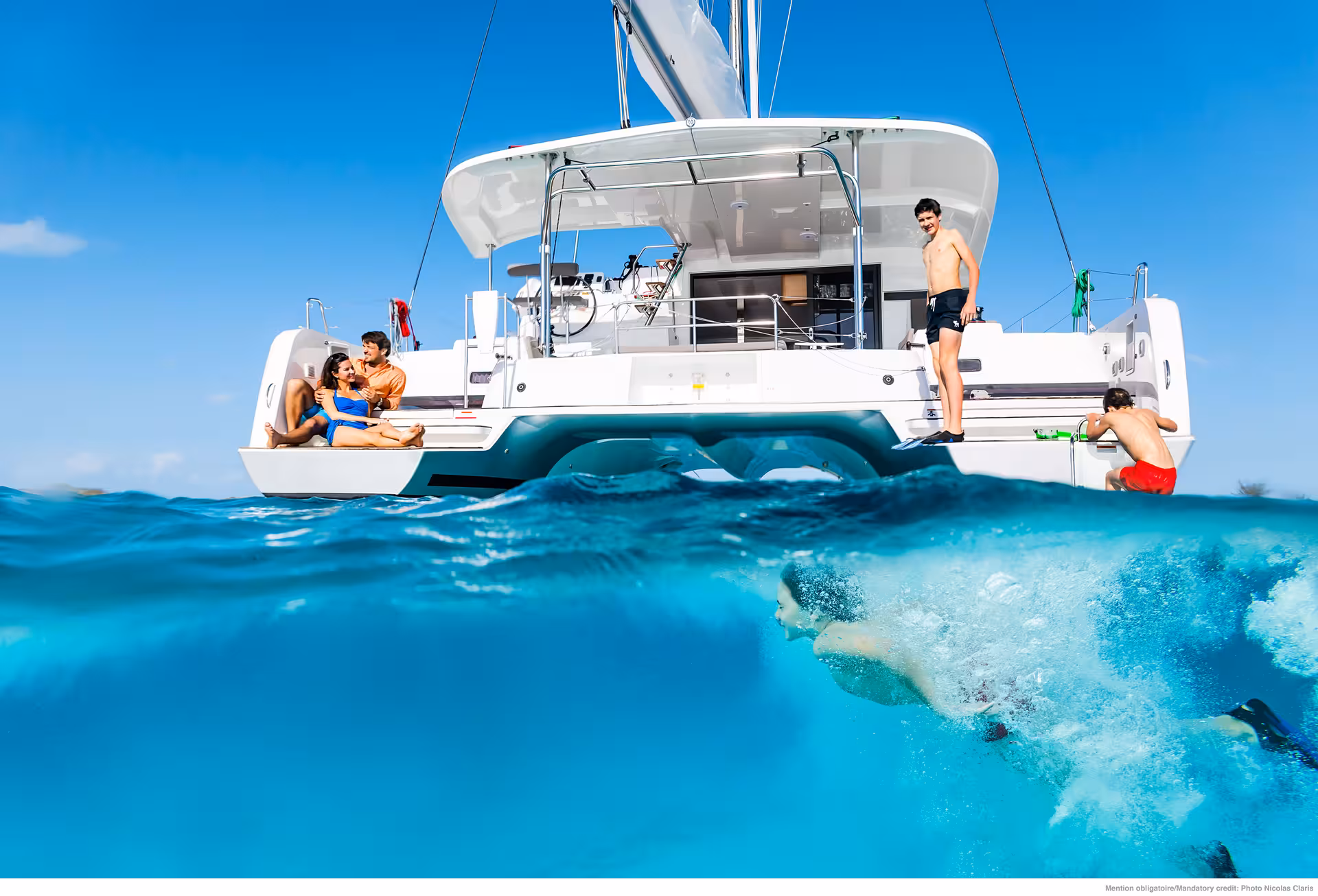 Fun & Swim catamaran cruise with snorkeling and swimming in crystal-clear turquoise sea, friends relaxing onboard