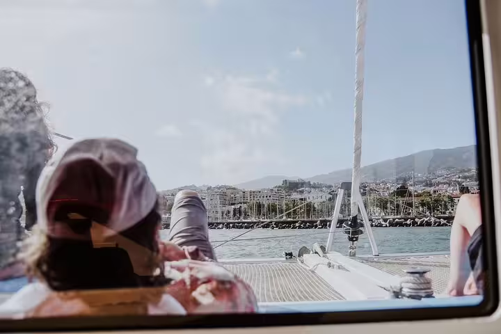 Relaxing on a luxury catamaran during a half-day tour on Madeira Island with scenic coastal views and sunny skies.