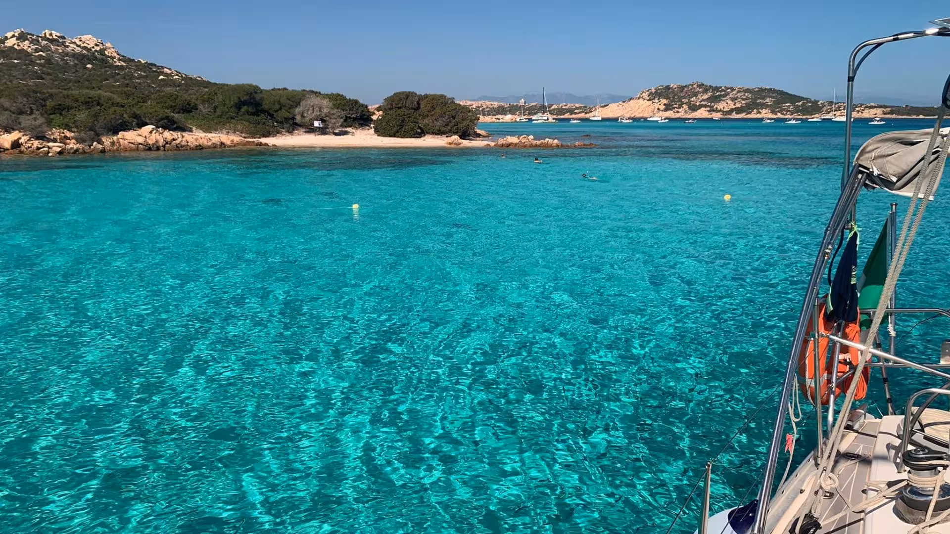 Turquoise waters and lush islands of La Maddalena Archipelago viewed from a catamaran deck in Palau.