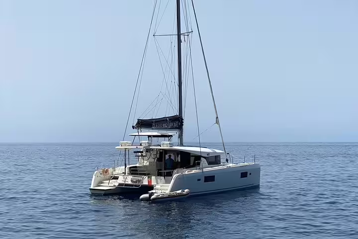 Luxury catamaran sailing on the serene waters of Madeira Island, ideal for a half-day tour exploring stunning coastal views.
