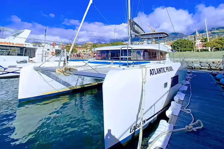 Luxury catamaran "Atlantic Pearl" docked on Madeira Island, ready for an unforgettable half-day tour adventure.
