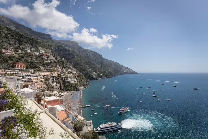 Panoramic view of Positano’s pastel houses, beach and boats along the Amalfi Coast from a luxury catamaran tour