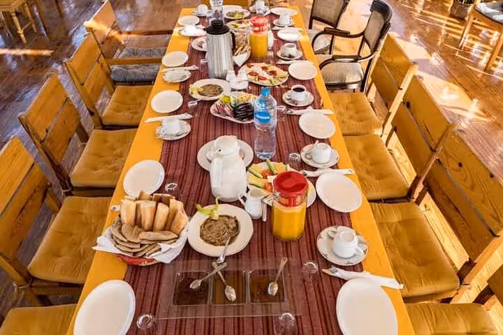Luxury dahabiya dining table set for breakfast on Nile cruise, part of 5-day Abu Simbel and hot air balloon tour