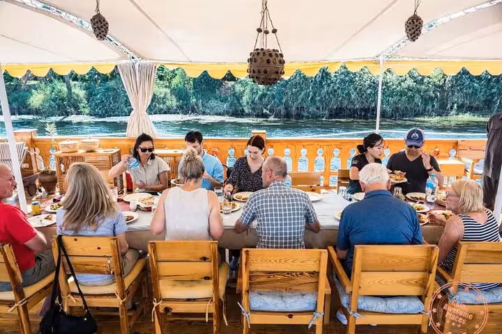 Guests dining on a private luxury dahabiya Nile cruise, part of 5-day Abu Simbel and hot air balloon package