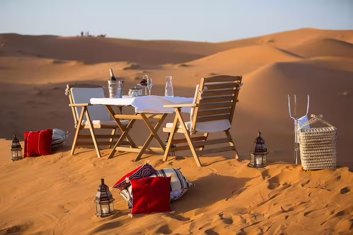 Luxury desert camp dining setup on Erg Chebbi dunes, Merzouga experience on 8 day desert tour from Marrakech